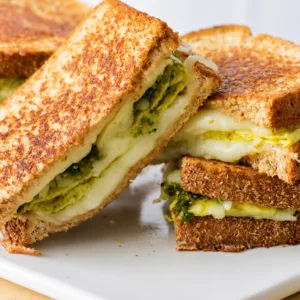 Delicious Pesto Eggs recipe served with tomatoes and mozzarella on toast.