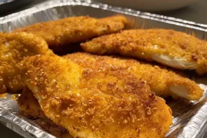 Crispy chicken cutlets served on a plate with fresh herbs