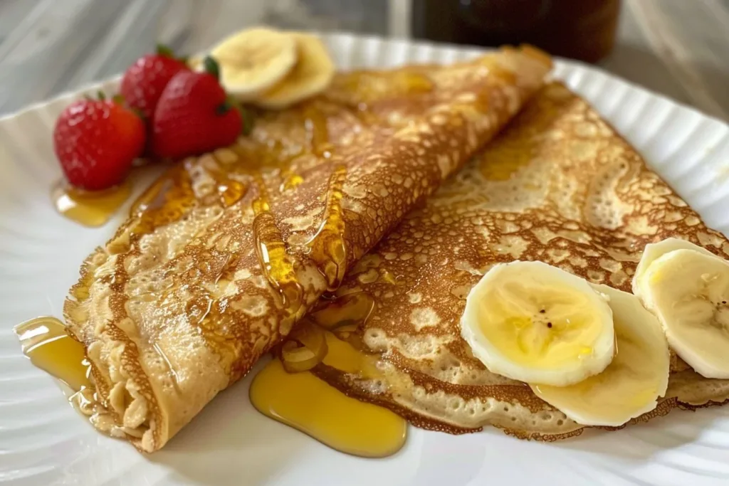 Healthy oatmeal crepes topped with fresh fruits and syrup