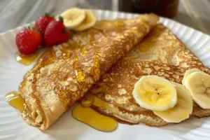 Healthy oatmeal crepes topped with fresh fruits and syrup