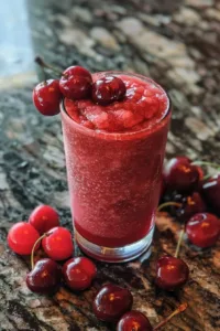 Delicious homemade cherry slushie in a glass with ice
