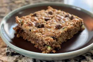 Delicious zucchini cobbler bars served on a wooden table.