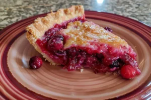 Deliciously baked cranberry custard pie with a flaky crust and berry topping.
